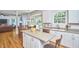 Open kitchen with a center island, white cabinetry, stainless steel appliances and view into the dining and living area at 5328 Willow Cry Ln, Raleigh, NC 27613