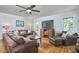 Bright living room with hardwood floors, comfortable leather seating, and a large television for entertainment at 5328 Willow Cry Ln, Raleigh, NC 27613