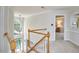 Staircase landing with wood railing, large windows, and access to an upstairs bedroom at 5328 Willow Cry Ln, Raleigh, NC 27613