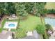Aerial view of backyard with pool, patio, basketball court, shed, and lush landscaping at 5629 Clearsprings Dr, Wake Forest, NC 27587