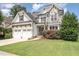 Charming two-story home featuring a stone facade, a three-car garage, and a well-manicured lawn at 5629 Clearsprings Dr, Wake Forest, NC 27587