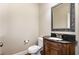 Traditional half bathroom features a dark wood vanity, granite countertop, and decorative mirror at 5629 Clearsprings Dr, Wake Forest, NC 27587