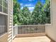 View of the wooden back porch with a railing and a view of trees and the blue sky at 5824 Cameo Glass Way, Raleigh, NC 27612