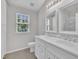 Bright bathroom with double sink vanity, modern mirrors and fixtures, and a window at 5824 Cameo Glass Way, Raleigh, NC 27612