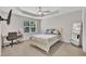 Bright bedroom with a ceiling fan, a window overlooking nature, carpet floors and a desk at 5824 Cameo Glass Way, Raleigh, NC 27612