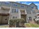 Exterior view of the townhome with balconies and well-manicured landscaping at 5824 Cameo Glass Way, Raleigh, NC 27612