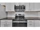 Close-up of a stainless steel oven with a built-in microwave and bright white cabinets at 5824 Cameo Glass Way, Raleigh, NC 27612
