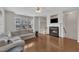 Spacious living room featuring a cozy fireplace, hardwood floors, a ceiling fan, and large windows at 5824 Cameo Glass Way, Raleigh, NC 27612