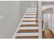 Elegant staircase with white risers and wood treads leading to the upper level at 5824 Cameo Glass Way, Raleigh, NC 27612