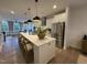 Bright, open kitchen featuring a large island, stainless steel appliances, and hardwood floors at 5900 Dunzo Dr, Raleigh, NC 27617