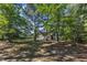 View of the backyard featuring mature trees, shade, and a partial view of the house at 6332 Mountain Oaks Way, Wake Forest, NC 27587