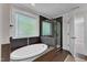 Stylish bathroom featuring a soaking tub, walk-in shower, and tiled walls at 6332 Mountain Oaks Way, Wake Forest, NC 27587