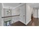 Hallway with hardwood floors and dark wood staircase railing at 6332 Mountain Oaks Way, Wake Forest, NC 27587