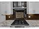 Close-up of the kitchen range with mosaic tile backsplash and stainless steel range hood at 6332 Mountain Oaks Way, Wake Forest, NC 27587