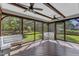A screened-in porch with fans and wood flooring provides a relaxing outdoor space with views of the backyard at 6332 Mountain Oaks Way, Wake Forest, NC 27587