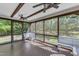 A covered, screened porch featuring three ceiling fans, brown trim, wood flooring, and white benches at 6332 Mountain Oaks Way, Wake Forest, NC 27587