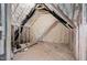 A spacious unfinished attic showcasing insulation and wooden beams, presents potential for customization at 703 E Markham Ave, Durham, NC 27701
