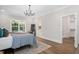 Bright bedroom boasts wood floors, a modern chandelier, and a walk-in closet, with an ensuite bathroom entrance at 703 E Markham Ave, Durham, NC 27701