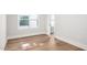 Neutral bedroom with wood-look floors, white trim, and a sunny window at 703 E Markham Ave, Durham, NC 27701