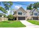 Charming two-story home with a gray roof, well-manicured lawn, and attached two car garage at 703 E Markham Ave, Durham, NC 27701