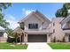 Charming two-story home featuring a gray roof, a two-car garage, and a well-manicured lawn at 703 E Markham Ave, Durham, NC 27701