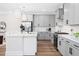 Stylish kitchen featuring white cabinets, stainless steel appliances, a spacious island, and modern pendant lighting at 703 E Markham Ave, Durham, NC 27701