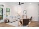 Cozy living room with a neutral color palette, comfortable seating, and natural light streaming in from a large window at 703 E Markham Ave, Durham, NC 27701