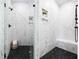 The shower features a black, overhead rain shower head, a handheld sprayer, and stylish marble wall tiles at 703 E Markham Ave, Durham, NC 27701