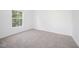 Clean, neutral bedroom with plush carpeting and a large window offering plenty of natural light at 709 Woodgreen Dr, Durham, NC 27704