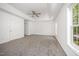 Main bedroom featuring tray ceilings, a ceiling fan, carpeting, and a large window at 709 Woodgreen Dr, Durham, NC 27704