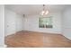 Bright dining area with hardwood floors, white trim, a modern chandelier and entry door at 709 Woodgreen Dr, Durham, NC 27704