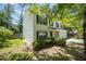 Well-maintained home with a lush green lawn, mature trees, and white siding with black shutters at 709 Woodgreen Dr, Durham, NC 27704