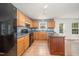 Bright kitchen with wood cabinets, center island, black appliances, and white trim at 709 Woodgreen Dr, Durham, NC 27704