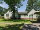 Charming home featuring a well-maintained lawn, mature trees, and a convenient carport at 714 Spring Ln, Sanford, NC 27330