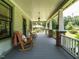 Inviting front porch featuring rocking chairs, wood flooring, and classic columns at 714 Spring Ln, Sanford, NC 27330