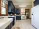Spacious kitchen with blue cabinets, white appliances, and a tiled floor at 714 Spring Ln, Sanford, NC 27330