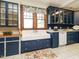 Charming kitchen featuring custom blue cabinets, an apron sink, tile floors, and a floral rug at 714 Spring Ln, Sanford, NC 27330