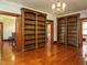 Open living room featuring hardwood floors, custom built-in bookshelves, and a chandelier at 714 Spring Ln, Sanford, NC 27330