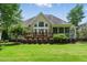 Beautiful backyard view of home with large deck, screened in porch, and green grass at 812 Bear Tree Crk, Chapel Hill, NC 27517