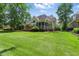 Expansive backyard featuring a lush lawn, mature trees, and a wooden deck with a screened porch at 812 Bear Tree Crk, Chapel Hill, NC 27517