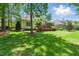 Spacious backyard featuring a lush lawn, mature trees, and a wooden deck with an additional screened porch at 812 Bear Tree Crk, Chapel Hill, NC 27517