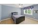 Blue bedroom featuring a comfy bed, side table, overhead fan, and a large bright window at 812 Bear Tree Crk, Chapel Hill, NC 27517