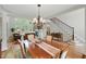 Open concept dining room with staircase view, hardwood floors, and a decorative chandelier at 812 Bear Tree Crk, Chapel Hill, NC 27517