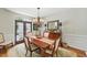 Dining room with wood floors, decorative chandelier, wainscoting, and large picture window at 812 Bear Tree Crk, Chapel Hill, NC 27517