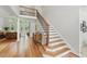 Elegant entryway featuring wood floors, staircase with iron spindles, and views into the living room at 812 Bear Tree Crk, Chapel Hill, NC 27517
