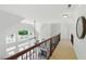 Bright hallway overlooking the downstairs Gathering room featuring railings with ornate wrought iron and bright windows at 812 Bear Tree Crk, Chapel Hill, NC 27517