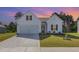 Charming one-story home with a manicured lawn and a two-car garage, showcasing a warm sunset backdrop at 823 Biltmore Dr, Sanford, NC 27332