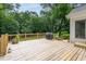 Expansive wooden deck with a grill, great for outdoor cooking and entertaining with a beautiful green backdrop at 8604 Timberwind Dr, Raleigh, NC 27615