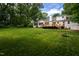 Large backyard with lush green lawn, deck, and tree swing, perfect for outdoor enjoyment at 8604 Timberwind Dr, Raleigh, NC 27615