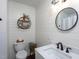 Bathroom featuring white shiplap walls, a round mirror, modern fixtures, and natural light at 8604 Timberwind Dr, Raleigh, NC 27615